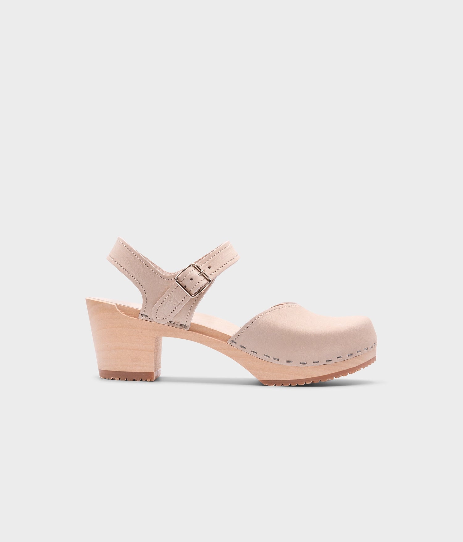 high heeled closed-toe clog sandal in sand white nubuck leather stapled on a light wooden base