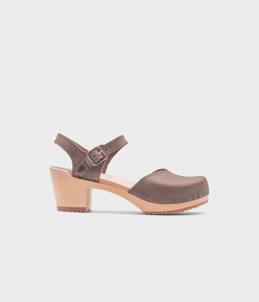 high heeled closed-toe clog sandal in stone grey nubuck leather stapled on a light wooden base