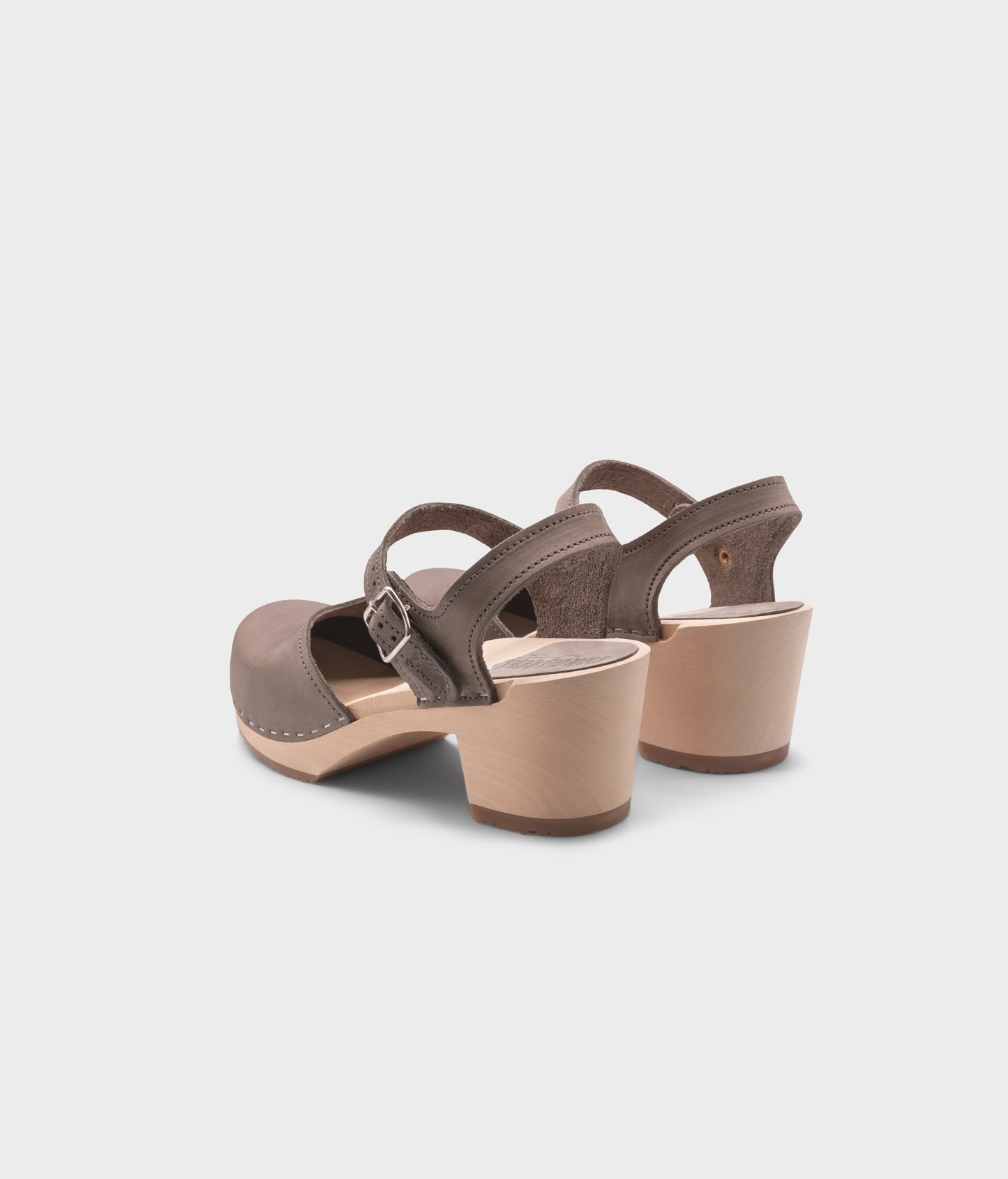 high heeled closed-toe clog sandal in stone grey nubuck leather stapled on a light wooden base