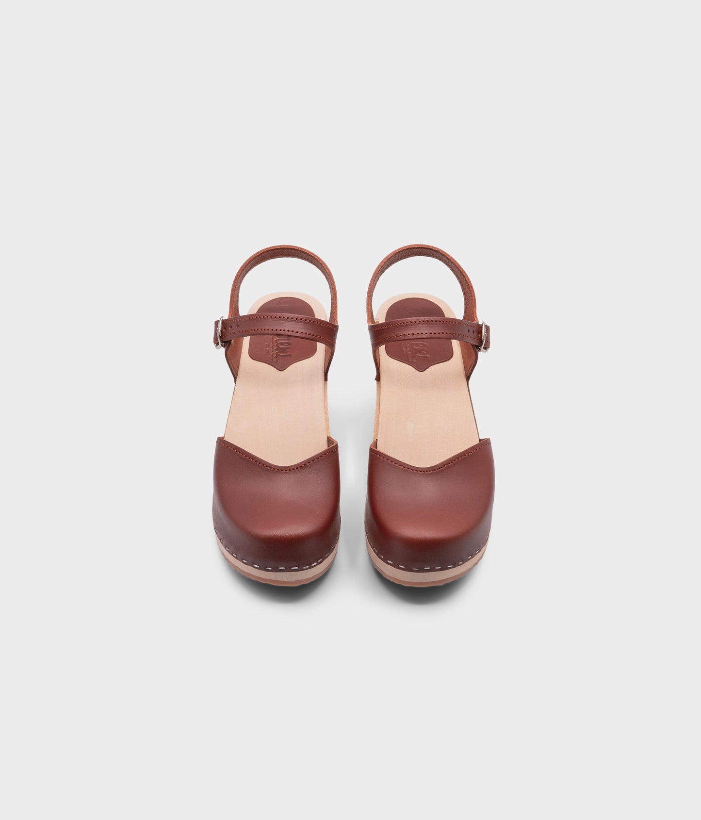 high heeled closed-toe clog sandal in cognac red vegetable tanned leather stapled on a light wooden base