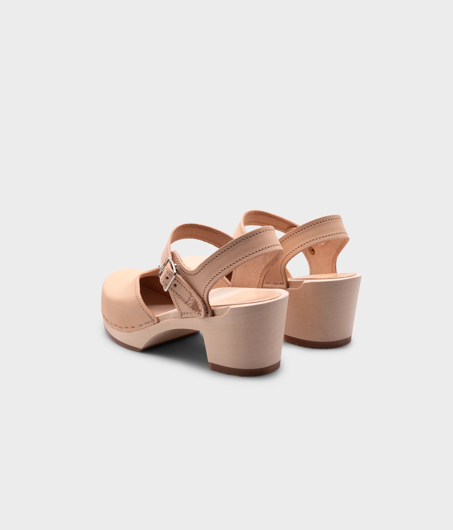 high heeled closed-toe clog sandal in ecru beige vegetable tanned leather stapled on a light wooden base