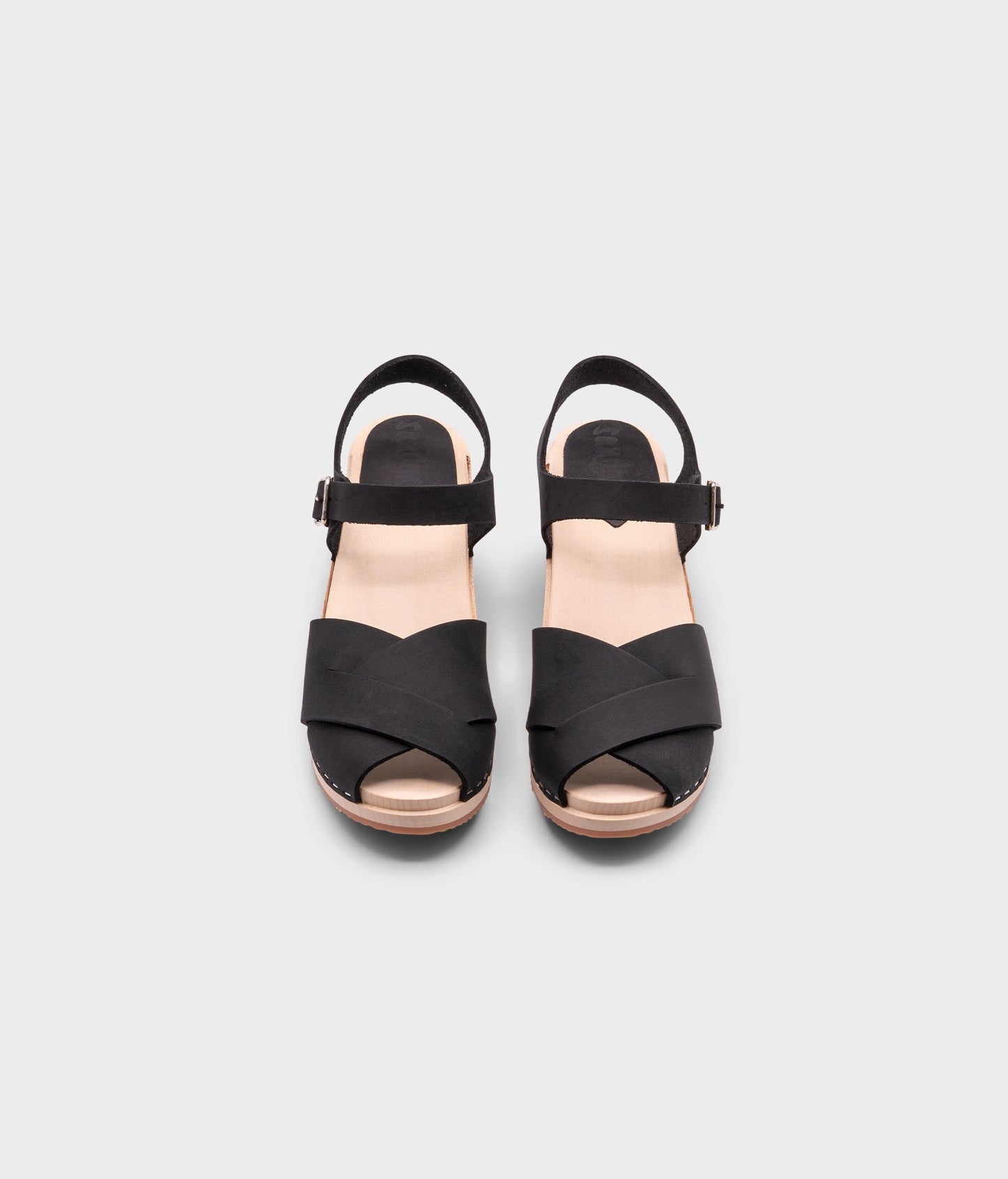 high heeled clog sandals in black nubuck leather with an open-toe stapled on a light wooden base