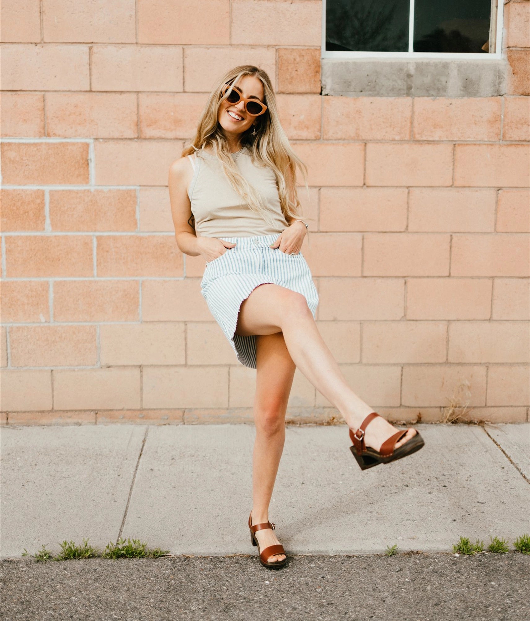 high-heeled open-toe clog sandal in cognac red vegetable tanned leather stapled on a dark wooden base