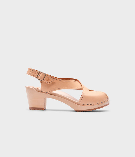 high heeled criss cross clog sandals in ecru beige vegetable tanned leather stapled on a light wooden base