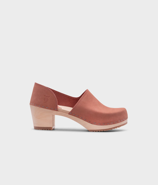high heeled closed-back clogs in blush pink nubuck leather stapled on a light wooden base