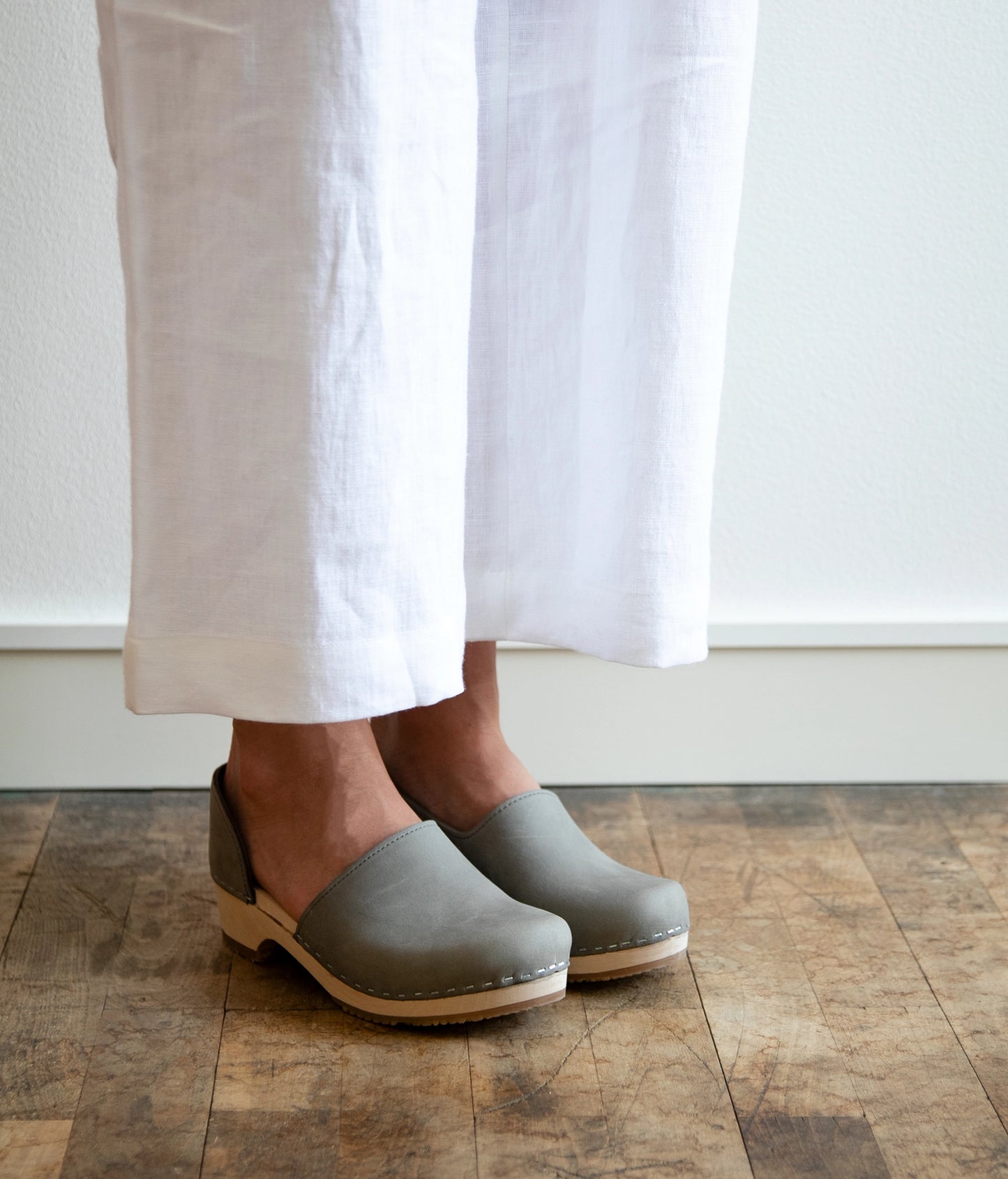 low heeled closed-back clogs in stone grey nubuck leather stapled on a light wooden base