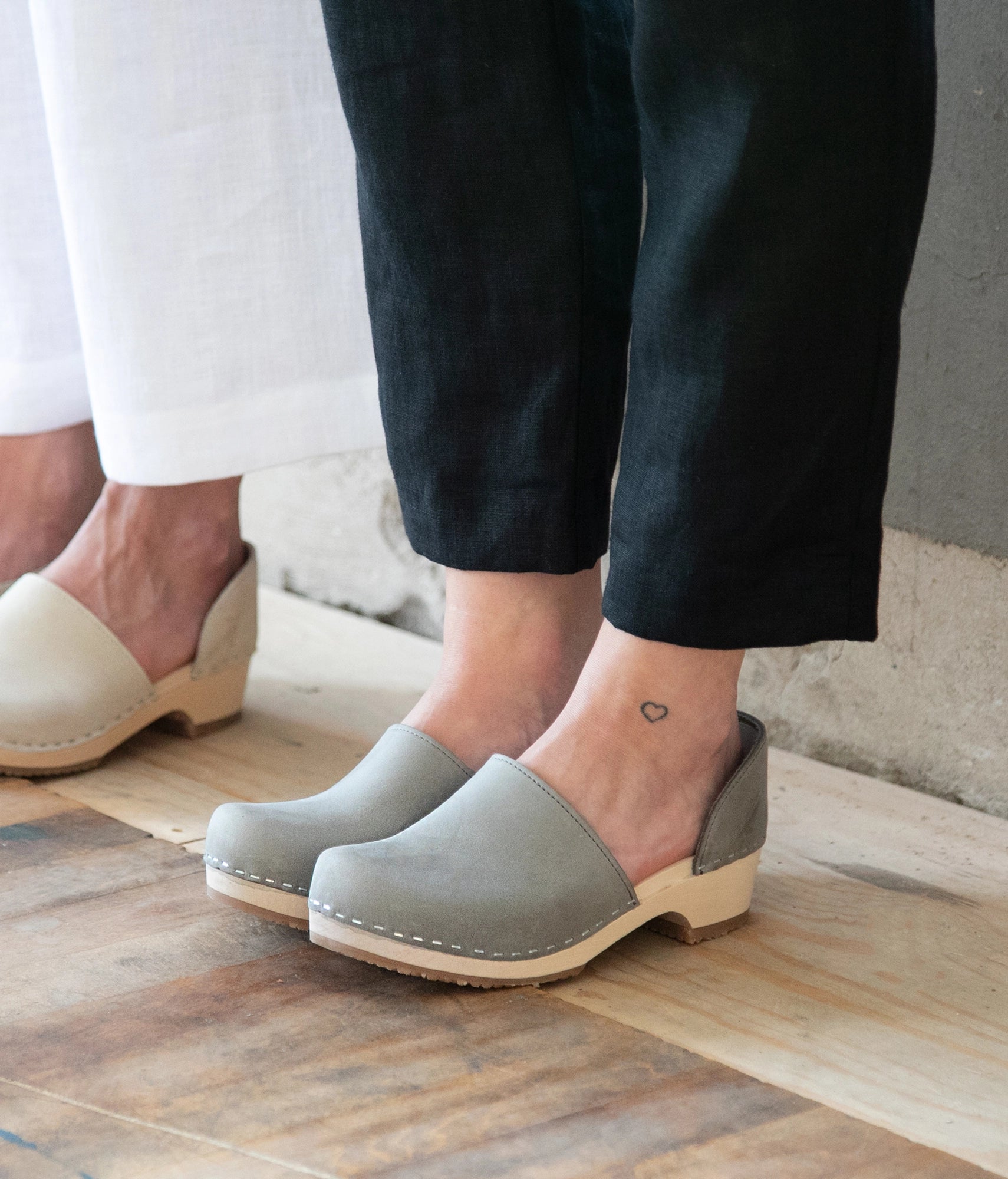 low heeled closed-back clogs in stone grey nubuck leather stapled on a light wooden base