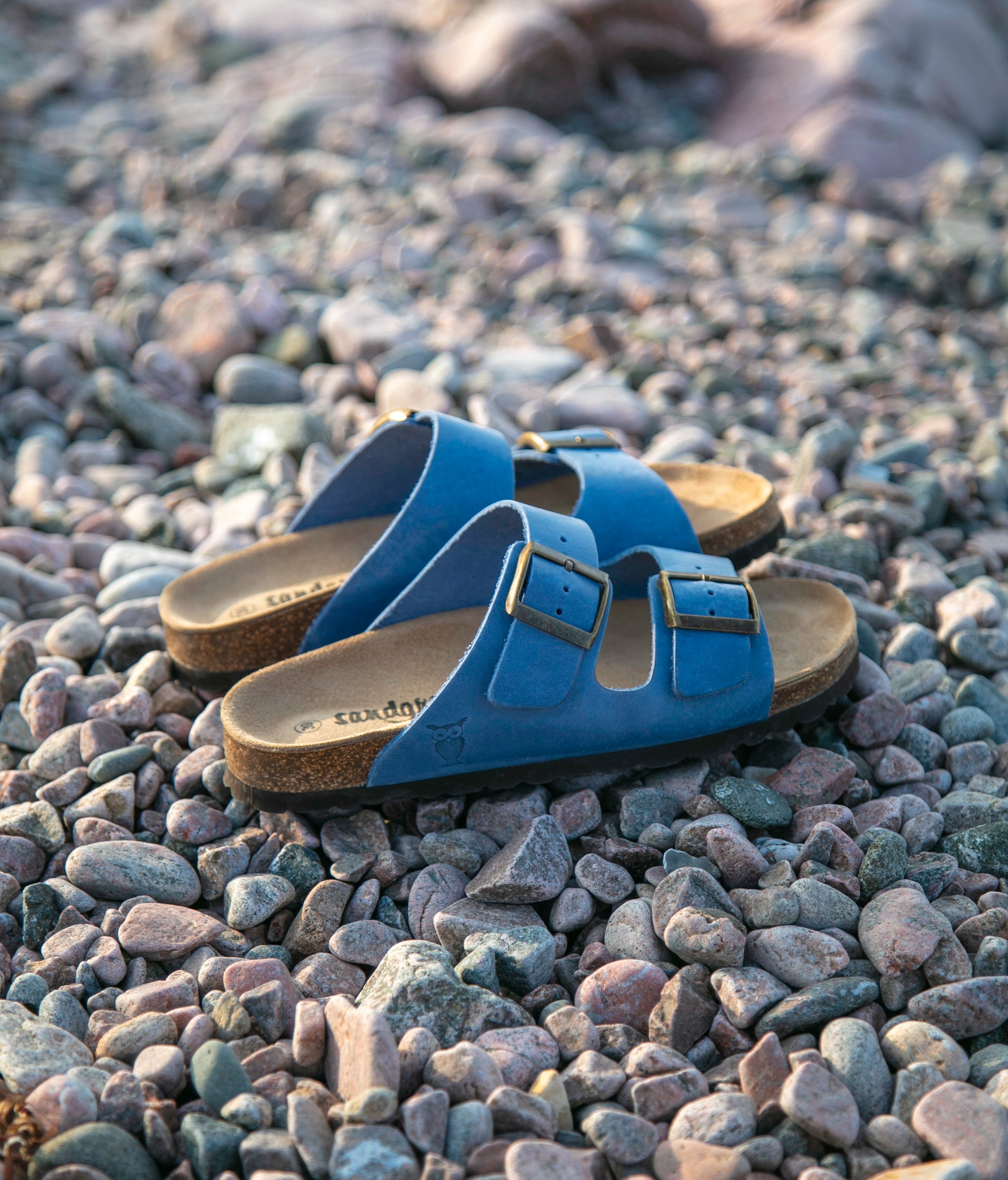 classic cork sandal with two straps in full-grain blue nubuck leather with a blue tint, suede footbed and brass gold studs