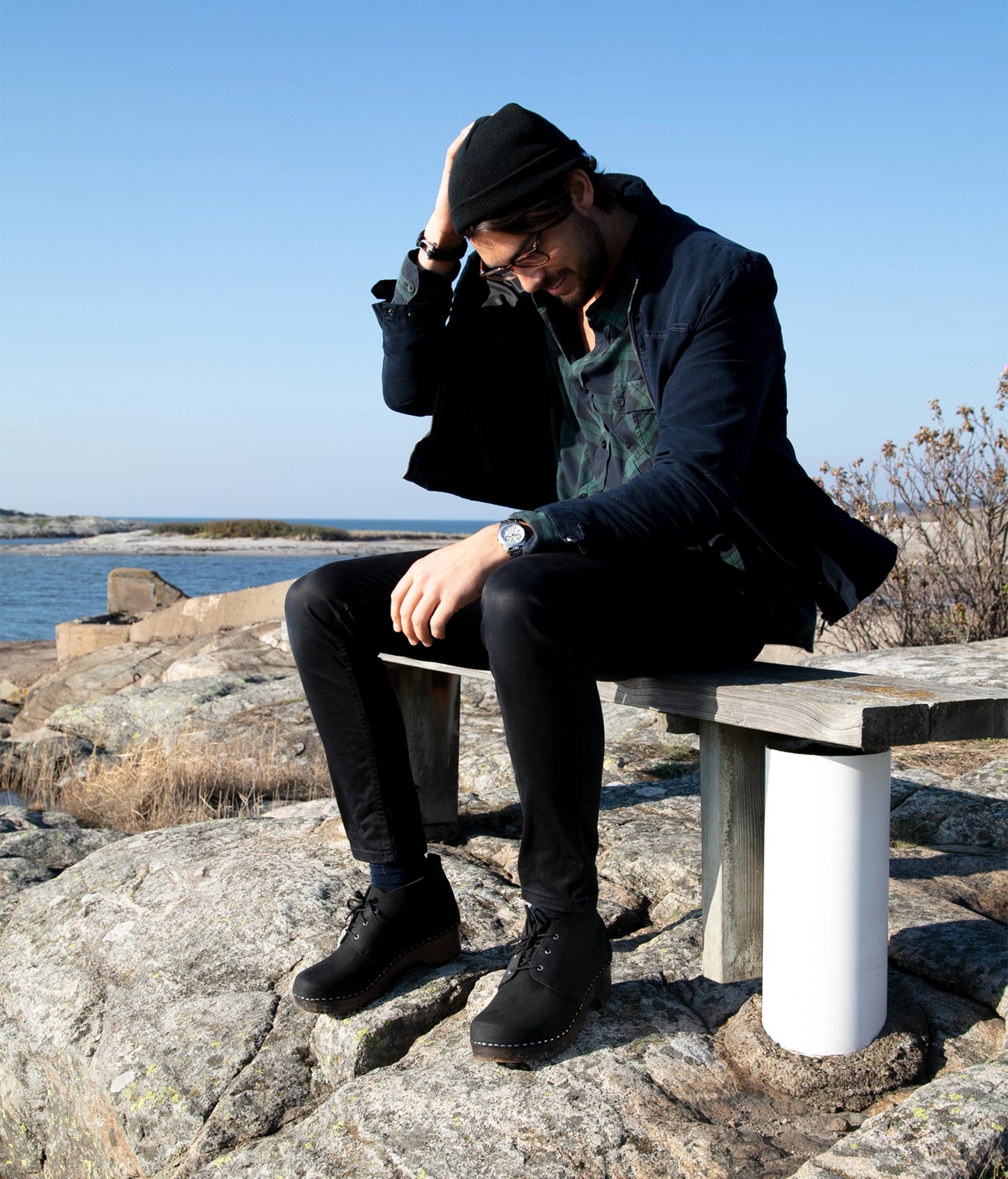 low heeled mens chukka clog boots in black nubuck leather stapled on a dark wooden base with black laces