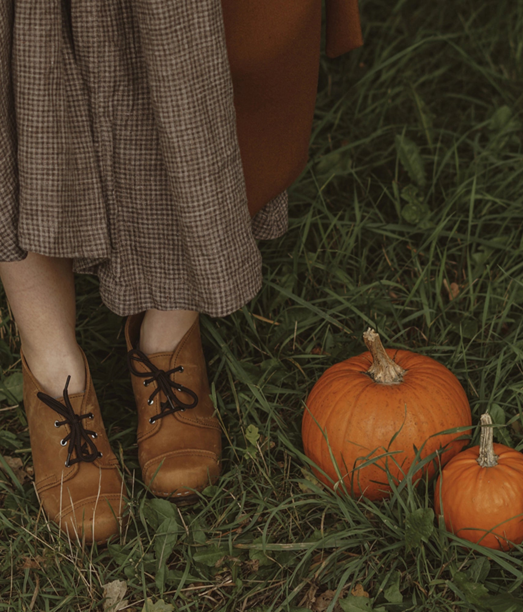 high heeled chukka clog boots in light brown nubuck leather stapled on a dark wooden base with brown laces