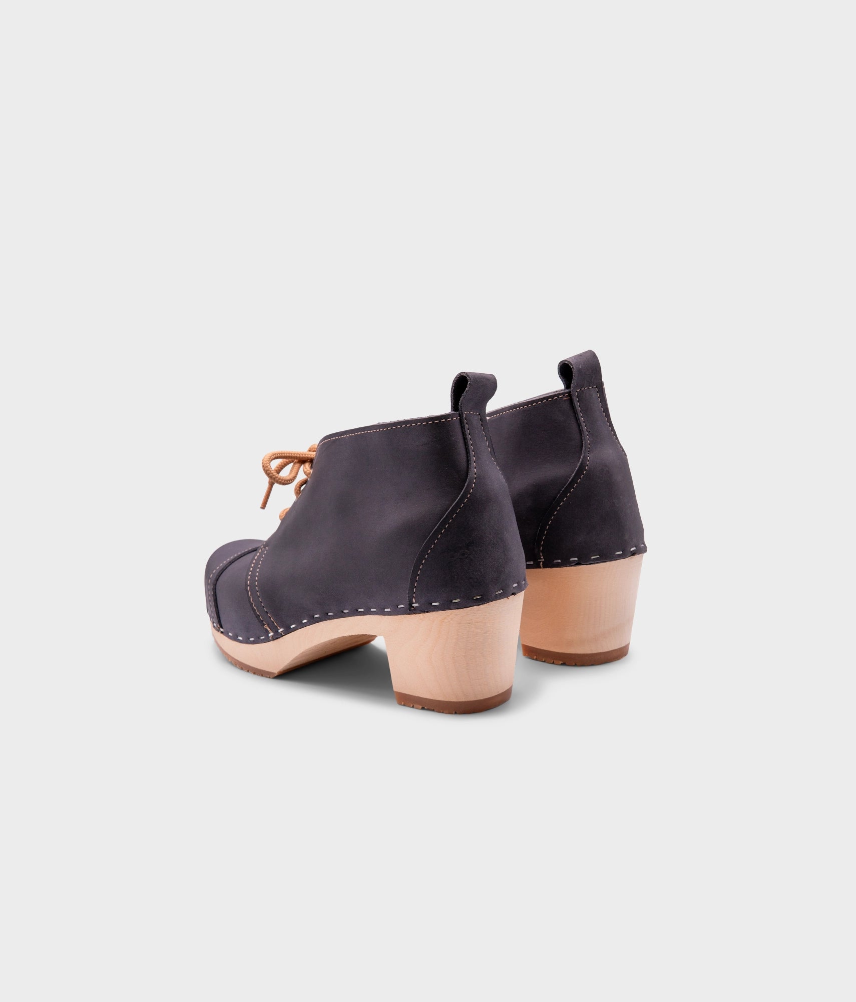 high heeled chukka clog boots in navy blue nubuck leather stapled on a light wooden base with beige laces