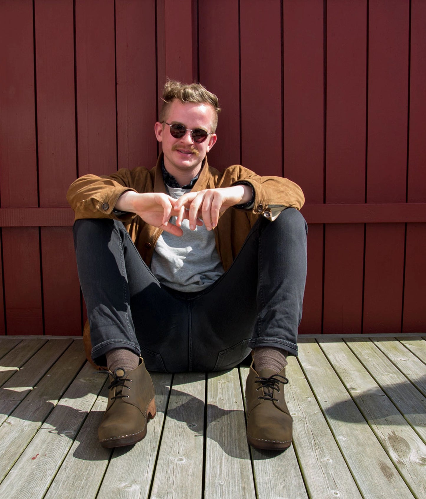 low heeled mens chukka clog boots in olive green nubuck leather stapled on a dark wooden base with brown laces