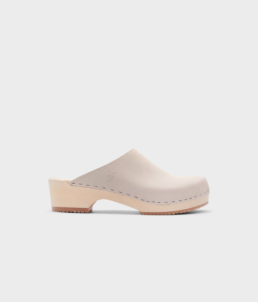low heeled minimalistic clog mules in sand white nubuck leather stapled on a light wooden base