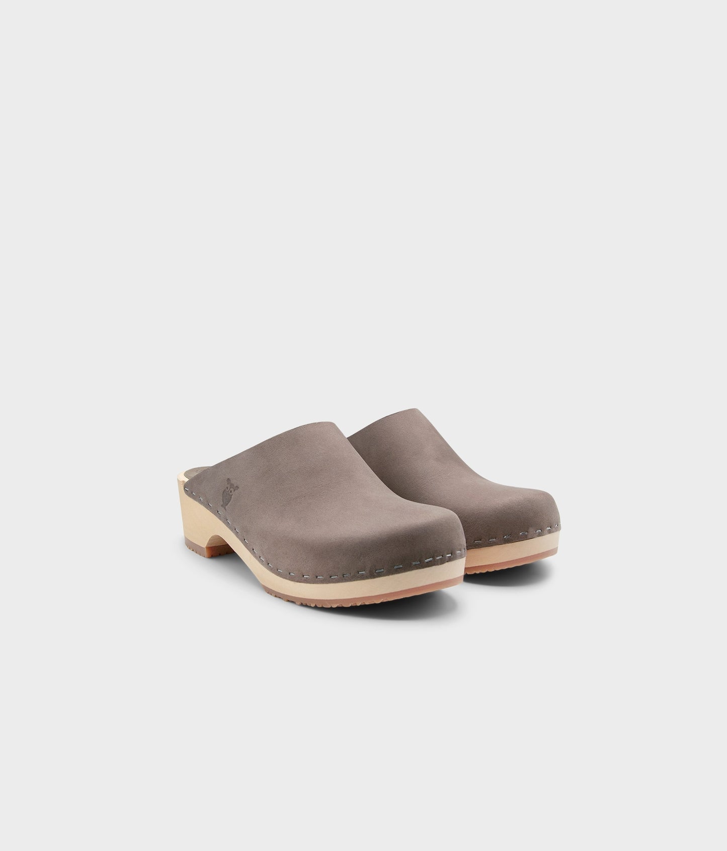 low heeled minimalistic clog mules in stone grey nubuck leather stapled on a light wooden base