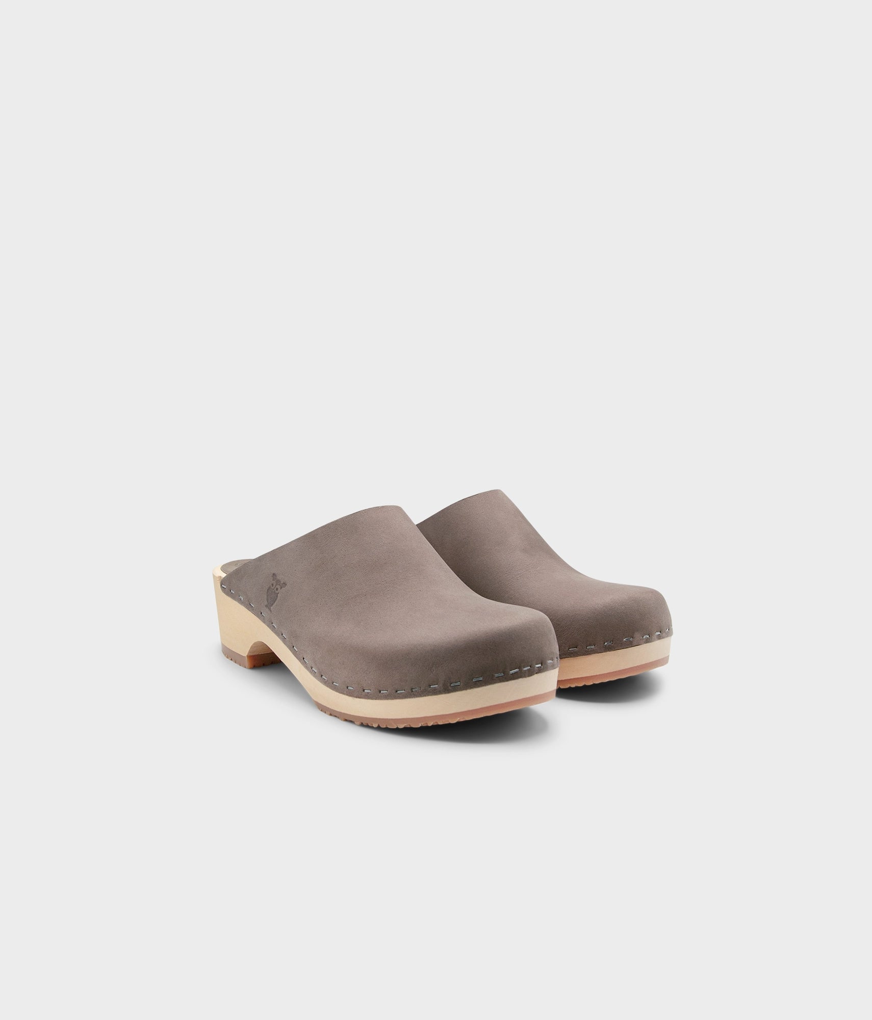 low heeled minimalistic clog mules in stone grey nubuck leather stapled on a light wooden base