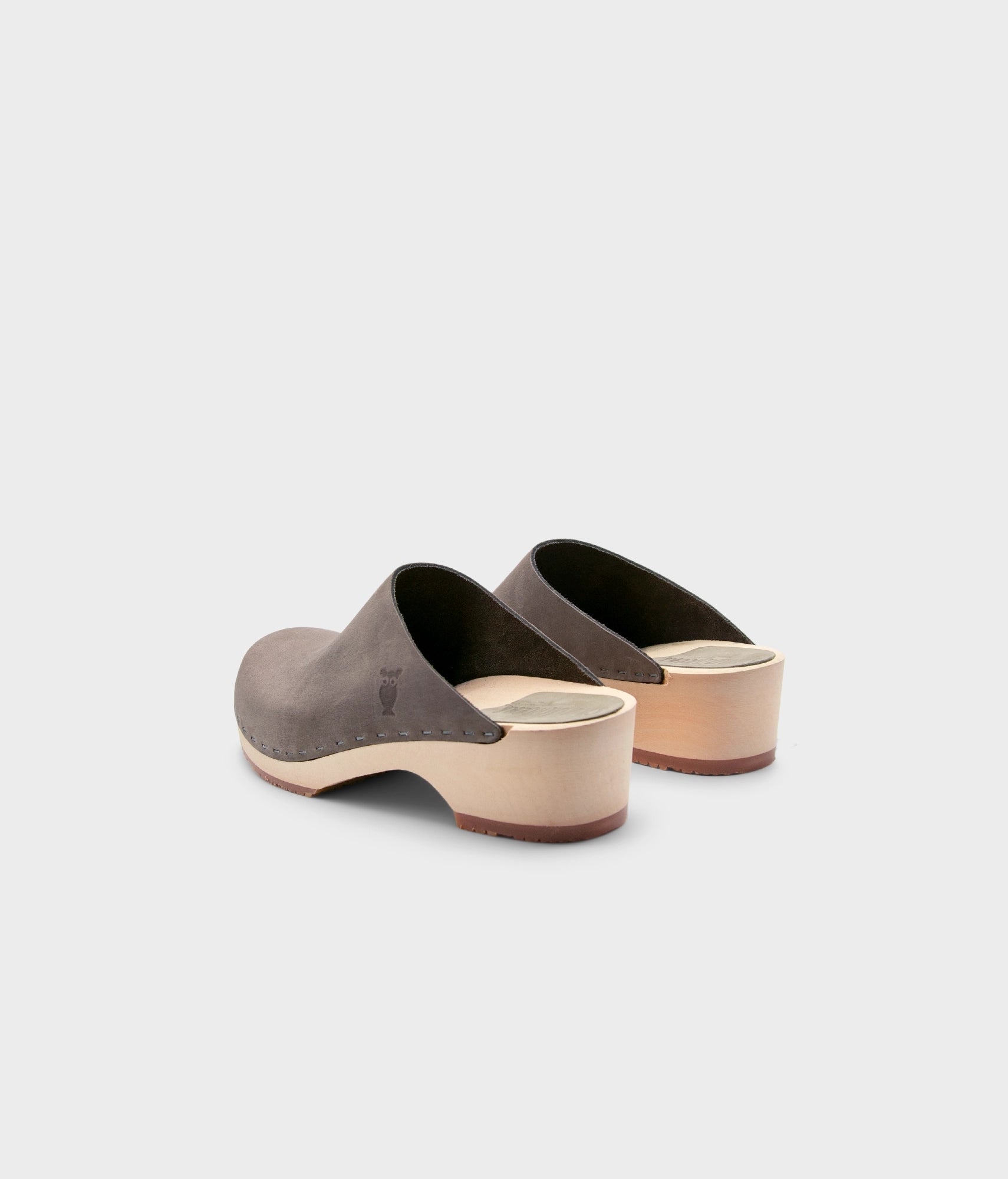 low heeled minimalistic clog mules in stone grey nubuck leather stapled on a light wooden base