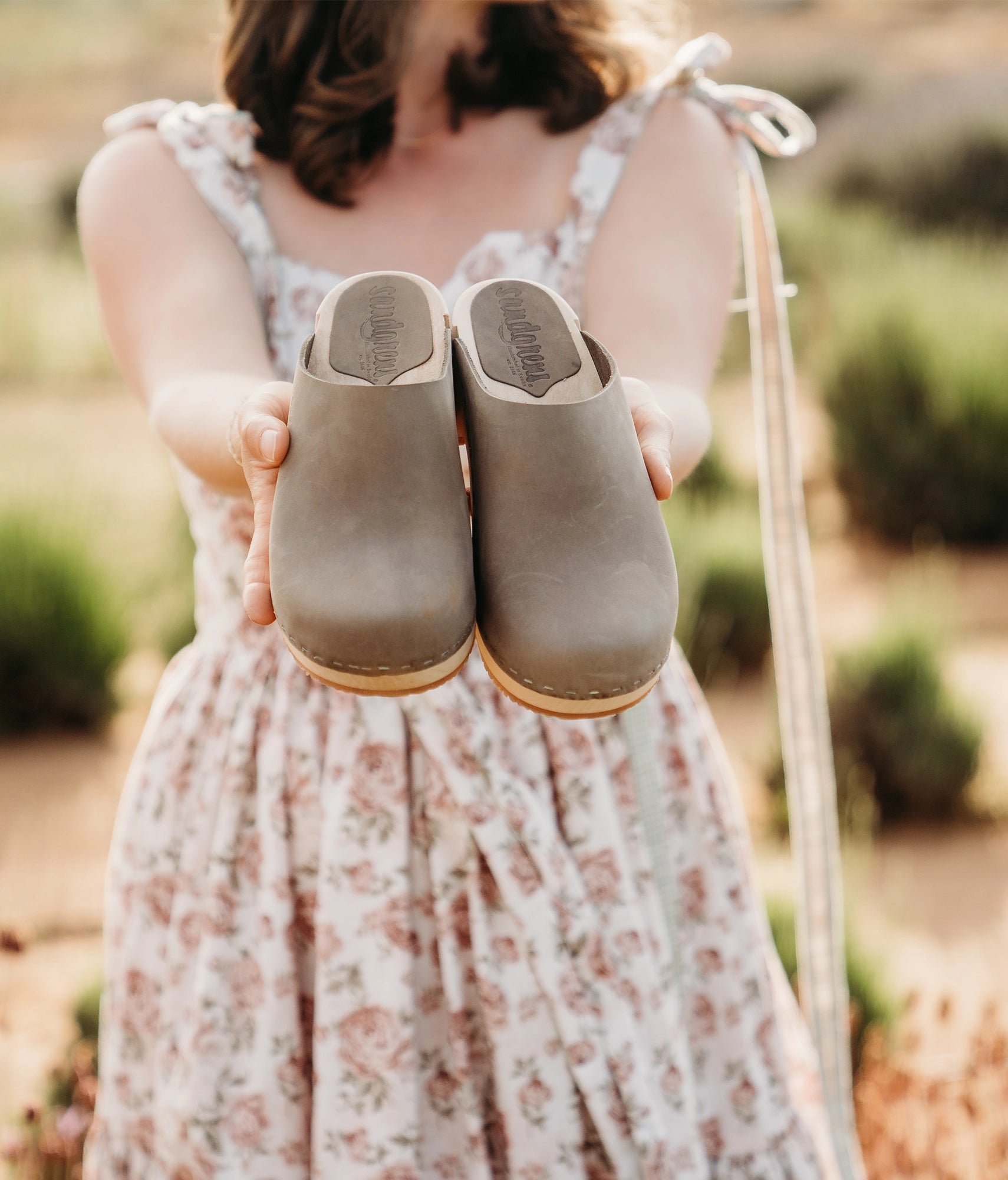 ow heeled minimalistic clog mules in stone grey nubuck leather stapled on a light wooden base