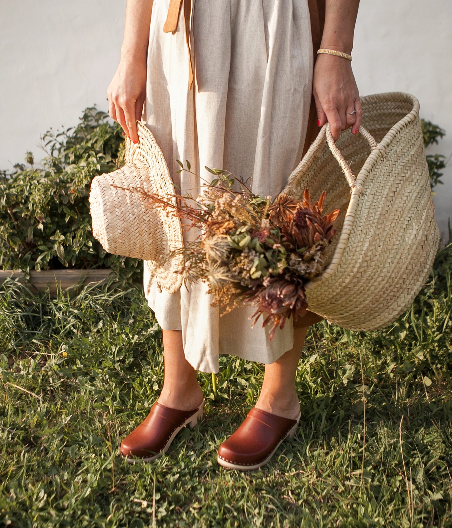 classic high heeled clog mule in cognac red vegetable tanned leather stapled on a light wooden base with a leather strap