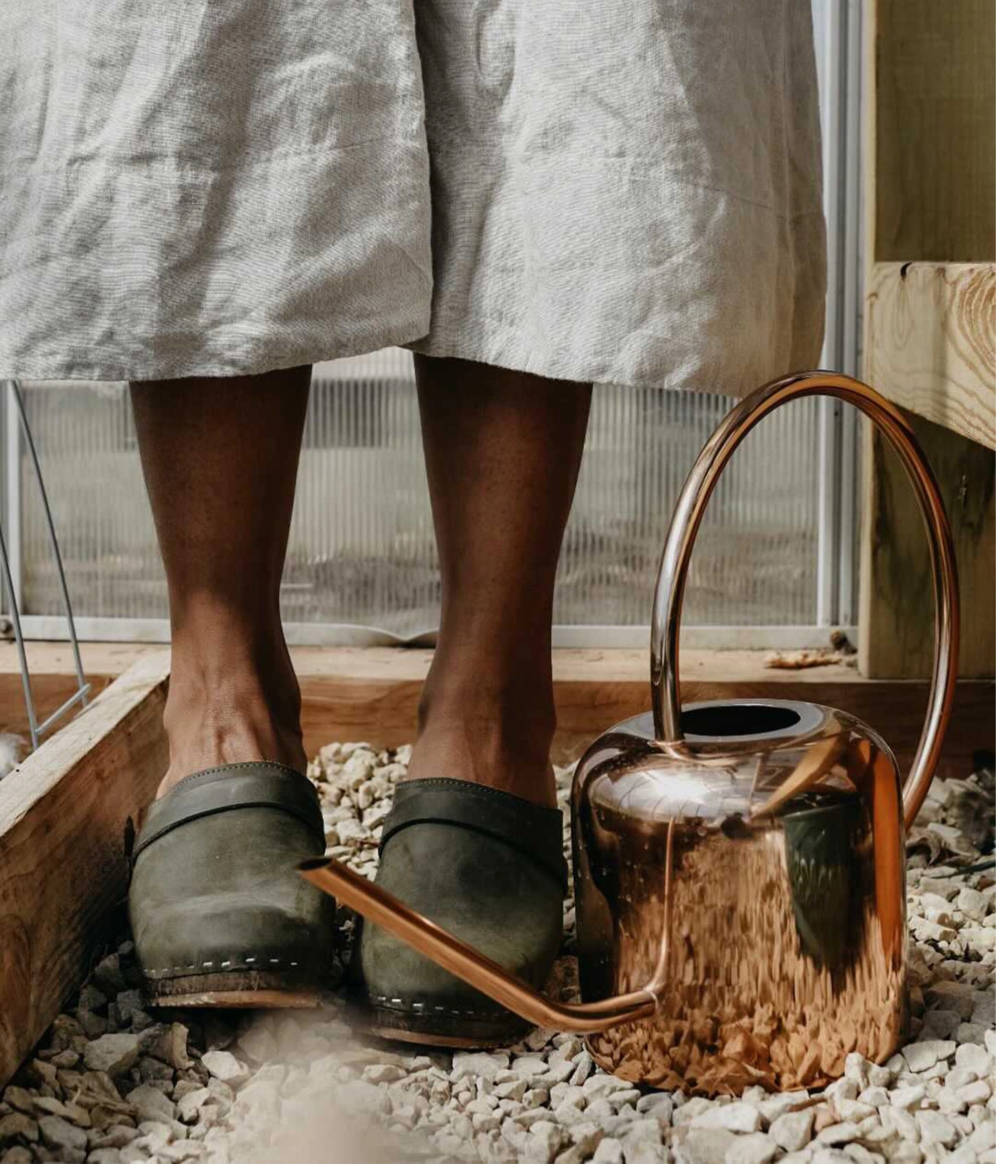 classic high heeled clog mule in olive green nubuck leather stapled on a dark wooden base with a leather strap