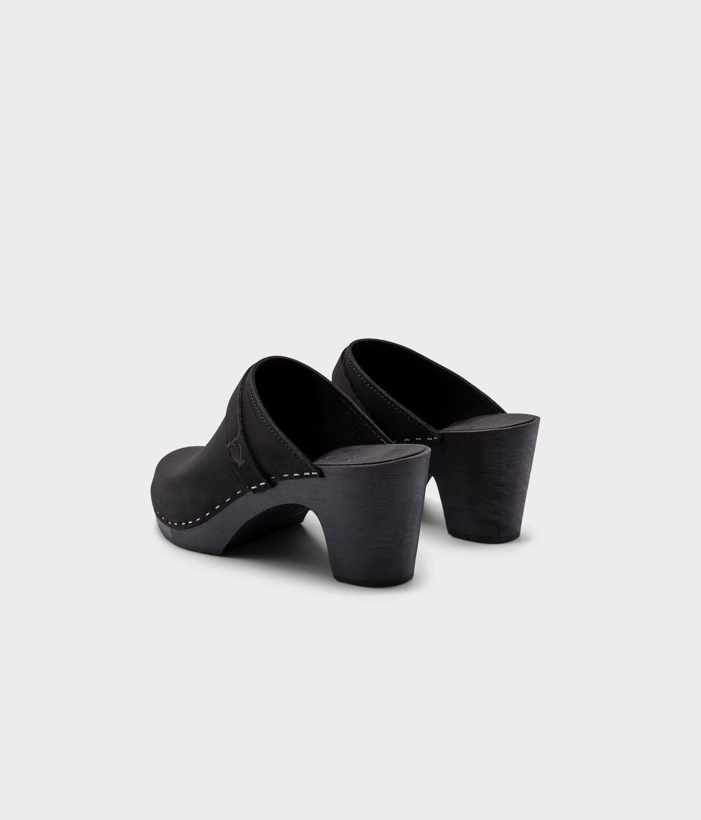 classic high rise heel clog mule in black nubuck leather stapled on a black wooden base