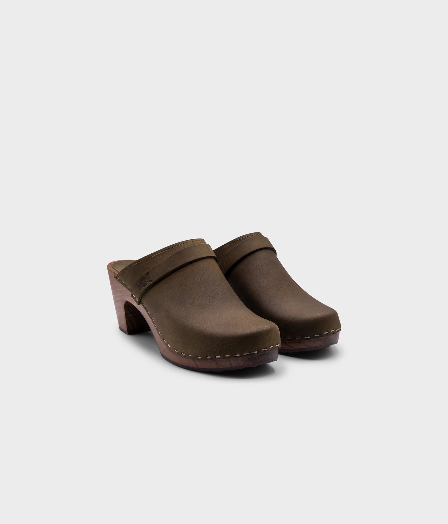classic high rise heel clog mule in olive green nubuck leather stapled on a dark wooden base