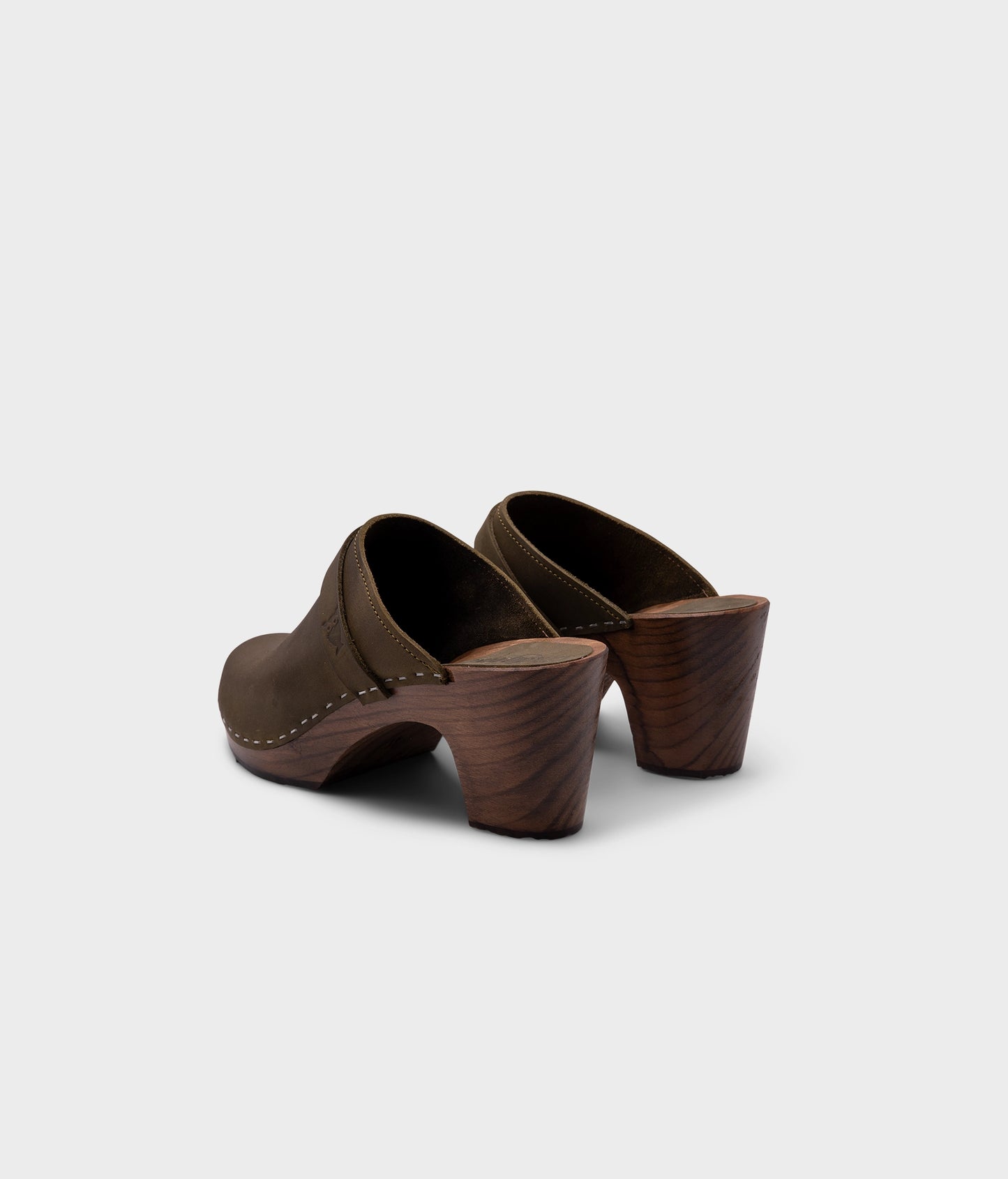 classic high rise heel clog mule in olive green nubuck leather stapled on a dark wooden base