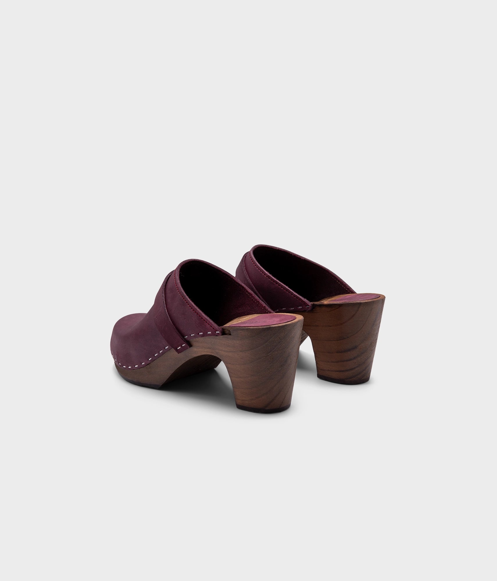 classic high rise heel clog mule in dark purple nubuck leather stapled on a dark wooden base