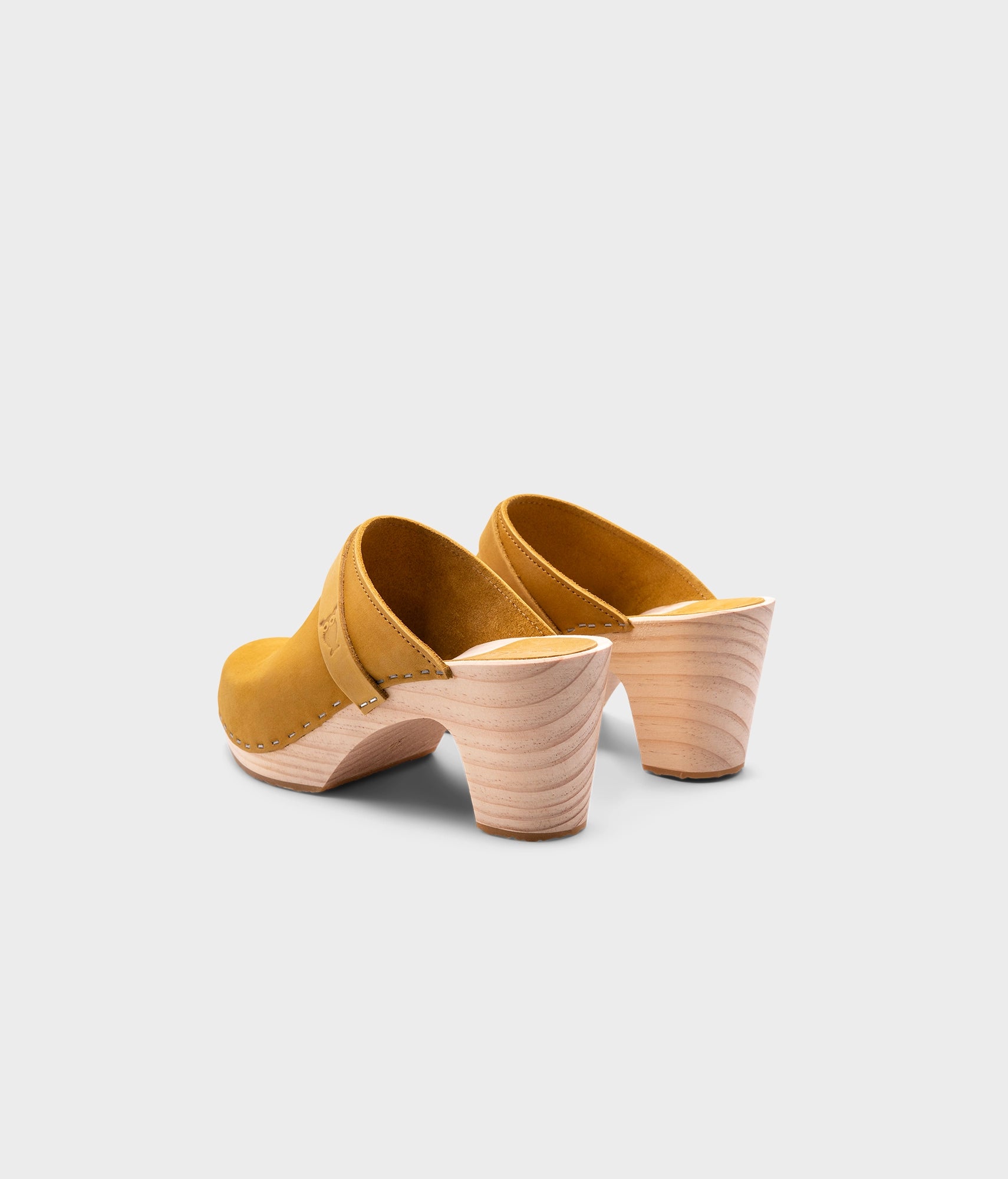 classic high rise heel clog mule in yellow nubuck leather stapled on a light wooden base