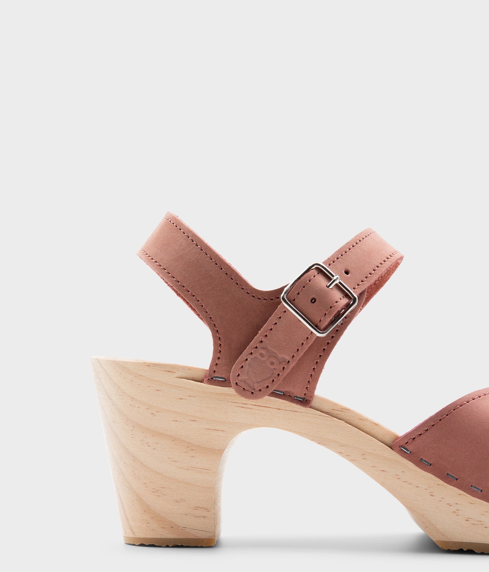 high rise heel crossed clog sandals in blush pink nubuck leather stapled on a light wooden base