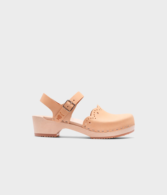 low heeled closed-toe clog sandals in ecru beige vegetable tanned leather with a wavy leather cutout stapled on a light wooden base