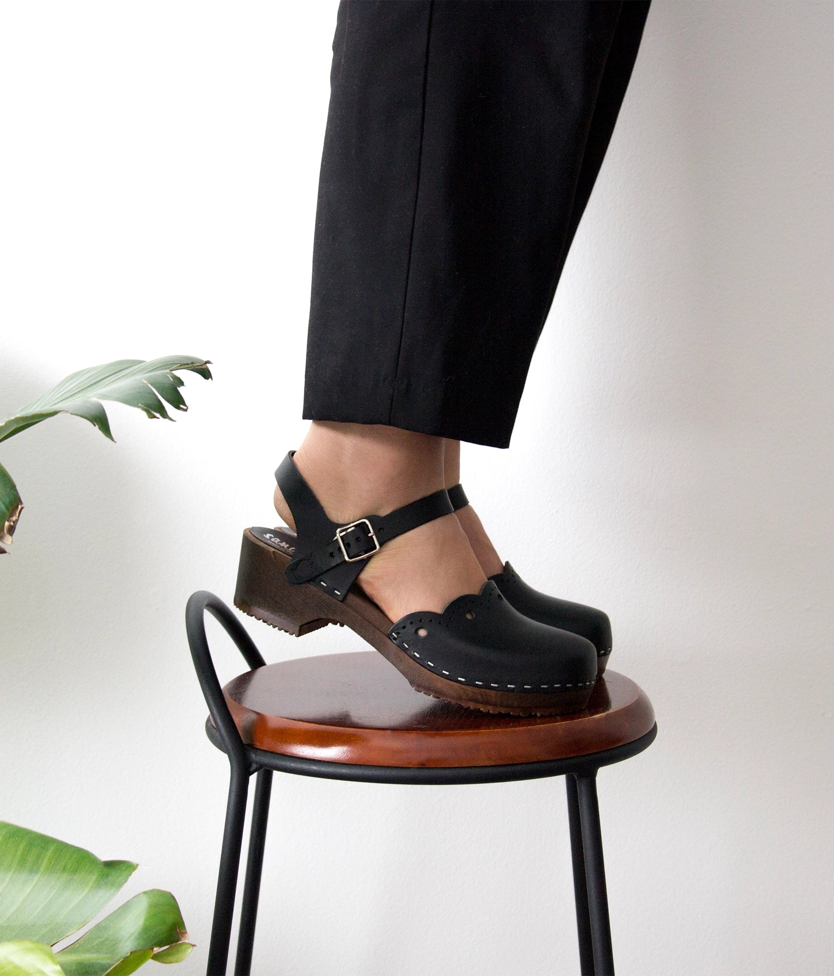 low heeled closed-toe clog sandals in black vegetable tanned leather with a wavy leather cutout stapled on a dark