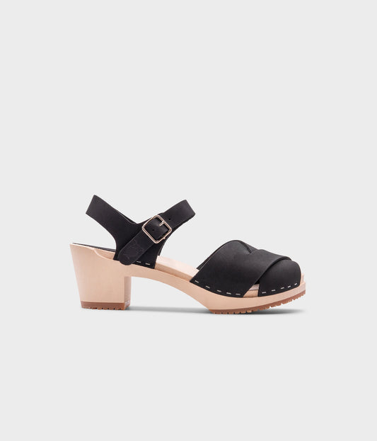 high heeled clog sandals in black nubuck leather with an open-toe stapled on a light wooden base