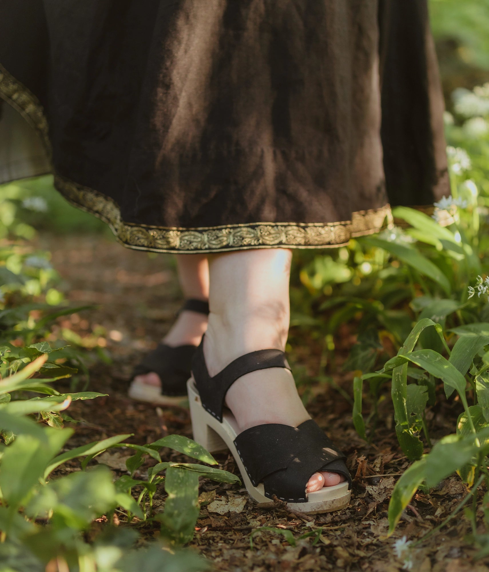 high heeled clog sandals in black nubuck leather with an open-toe stapled on a light wooden base