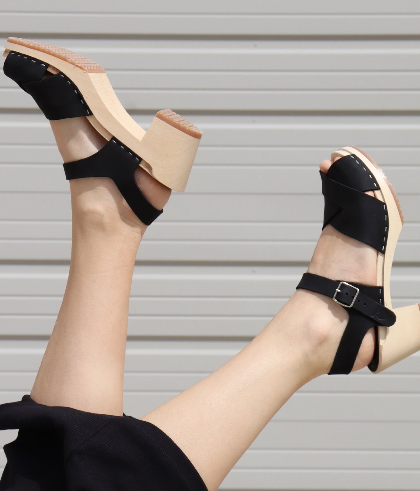 high heeled clog sandals in blush pink nubuck leather with an open-toe stapled on a light wooden base