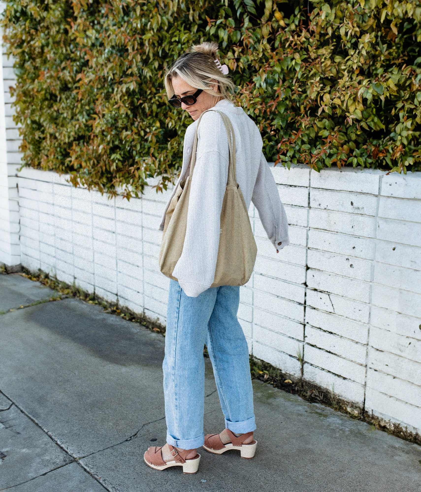high heeled clog sandals in blush pink nubuck leather with an open-toe stapled on a light wooden base