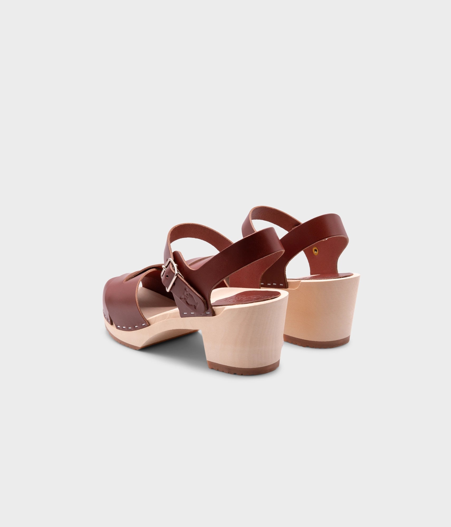 high heeled clog sandals in cognac red vegetable tanned leather with an open-toe stapled on a light wooden base