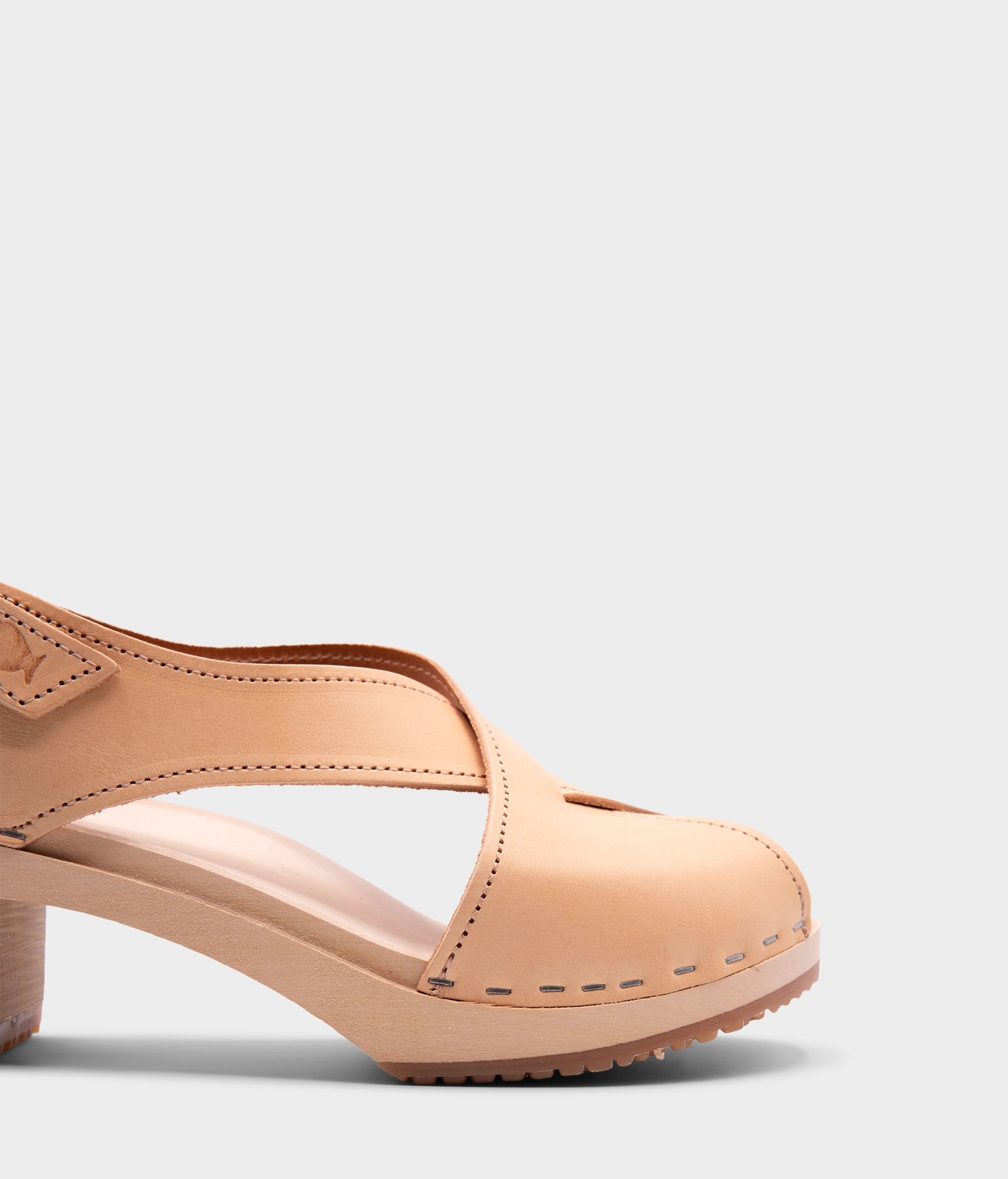high heeled criss cross clog sandals in ecru beige vegetable tanned leather stapled on a light wooden base