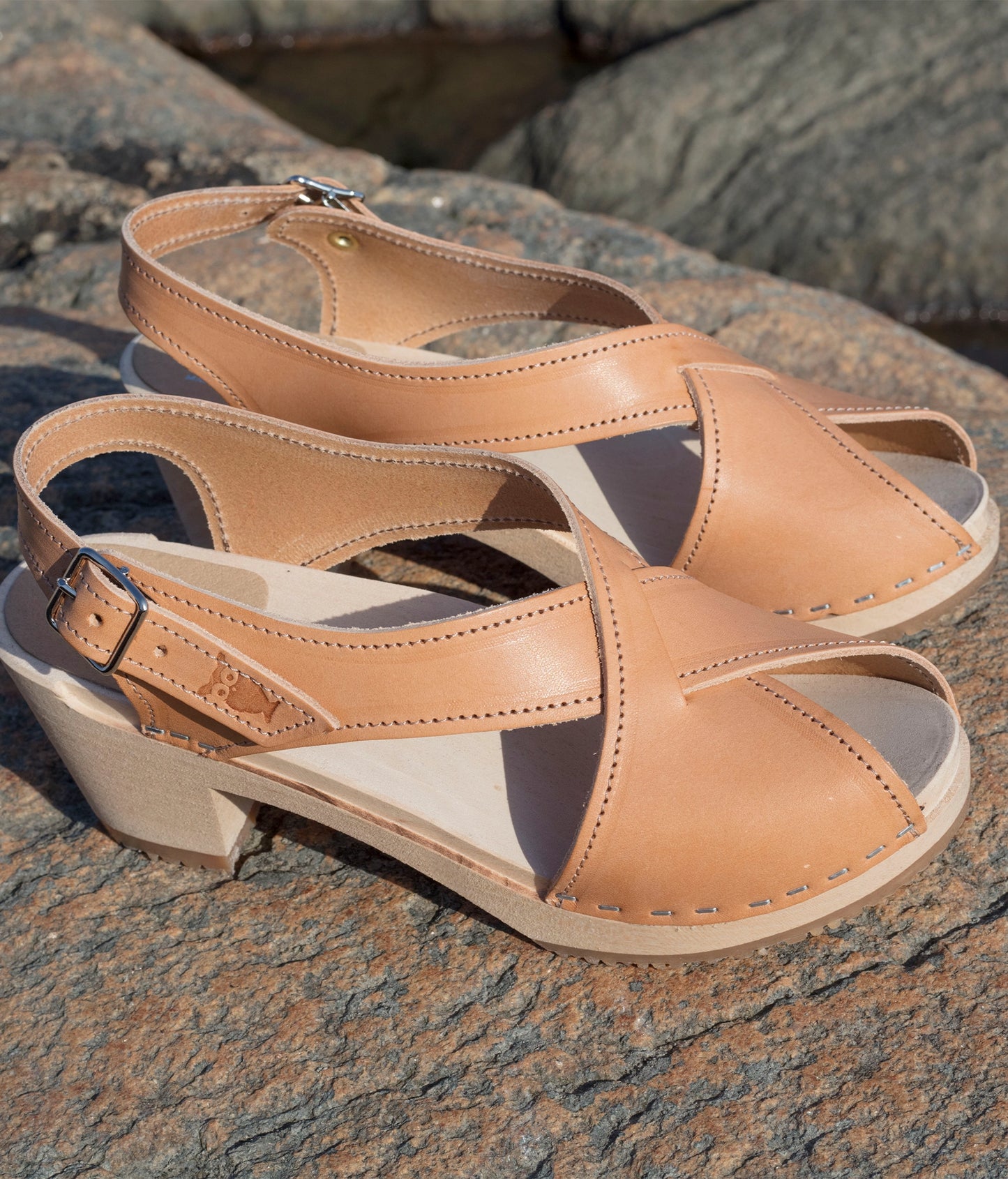 high heeled criss cross clog sandals in ecru beige vegetable tanned leather stapled on a light wooden base