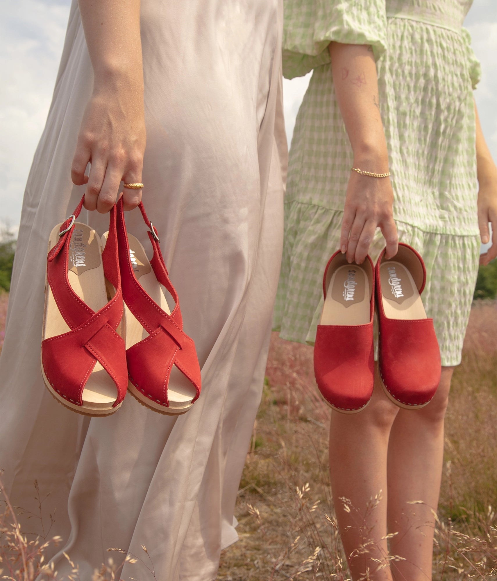 high heeled criss cross clog sandals in red nubuck leather stapled on a light wooden base
