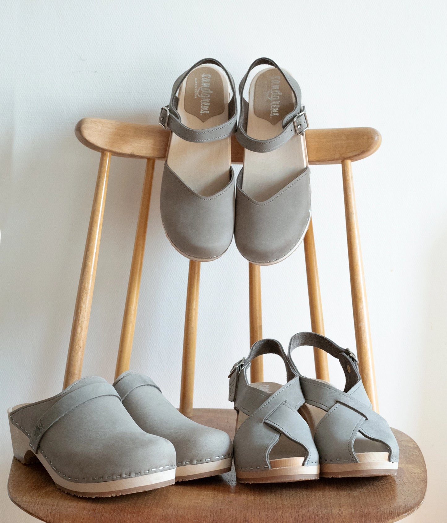 high heeled criss cross clog sandals in stone grey nubuck leather stapled on a light wooden base