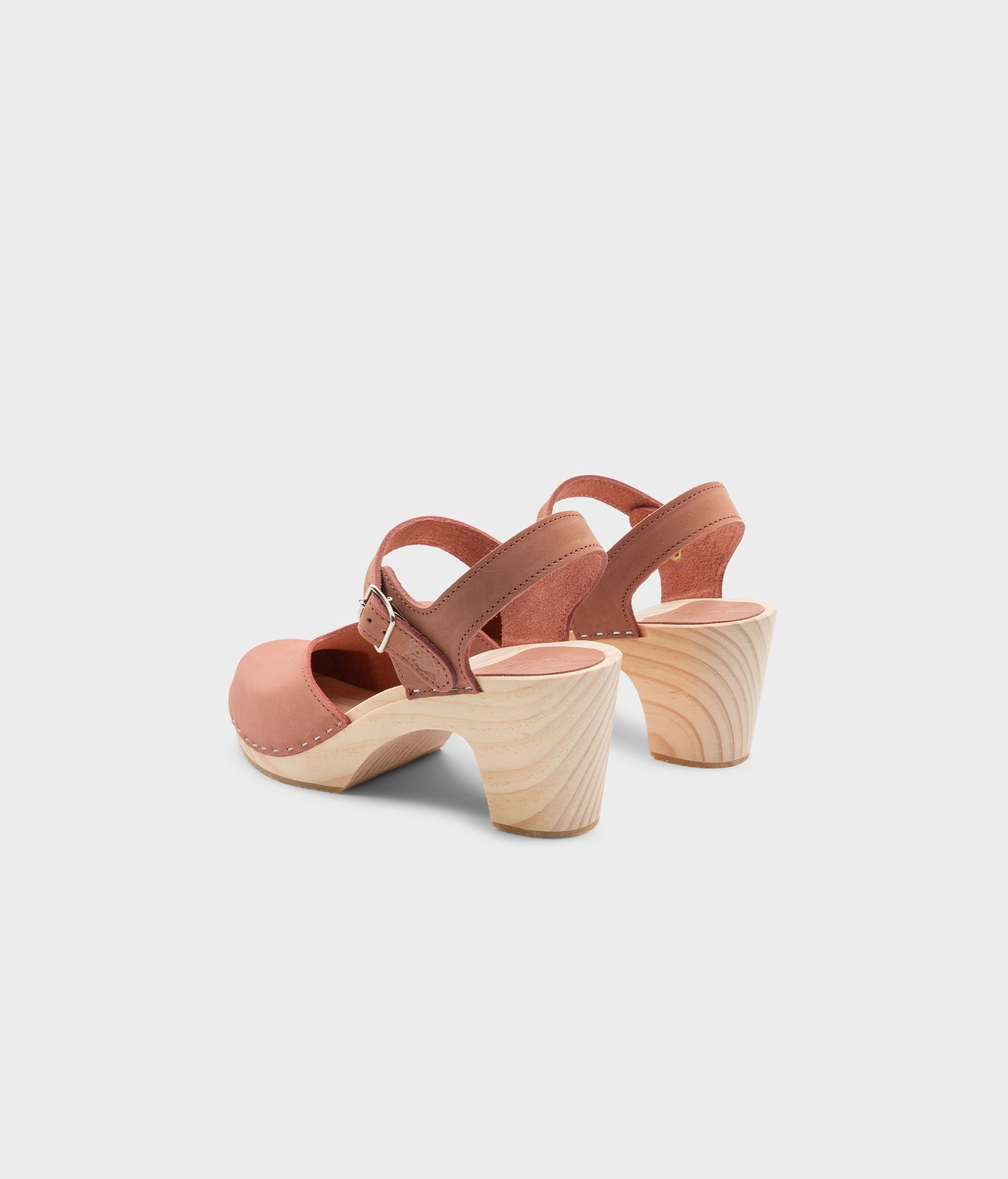 High rise heel classic clog sandals in blush pink nubuck leather stapled on a light wooden base