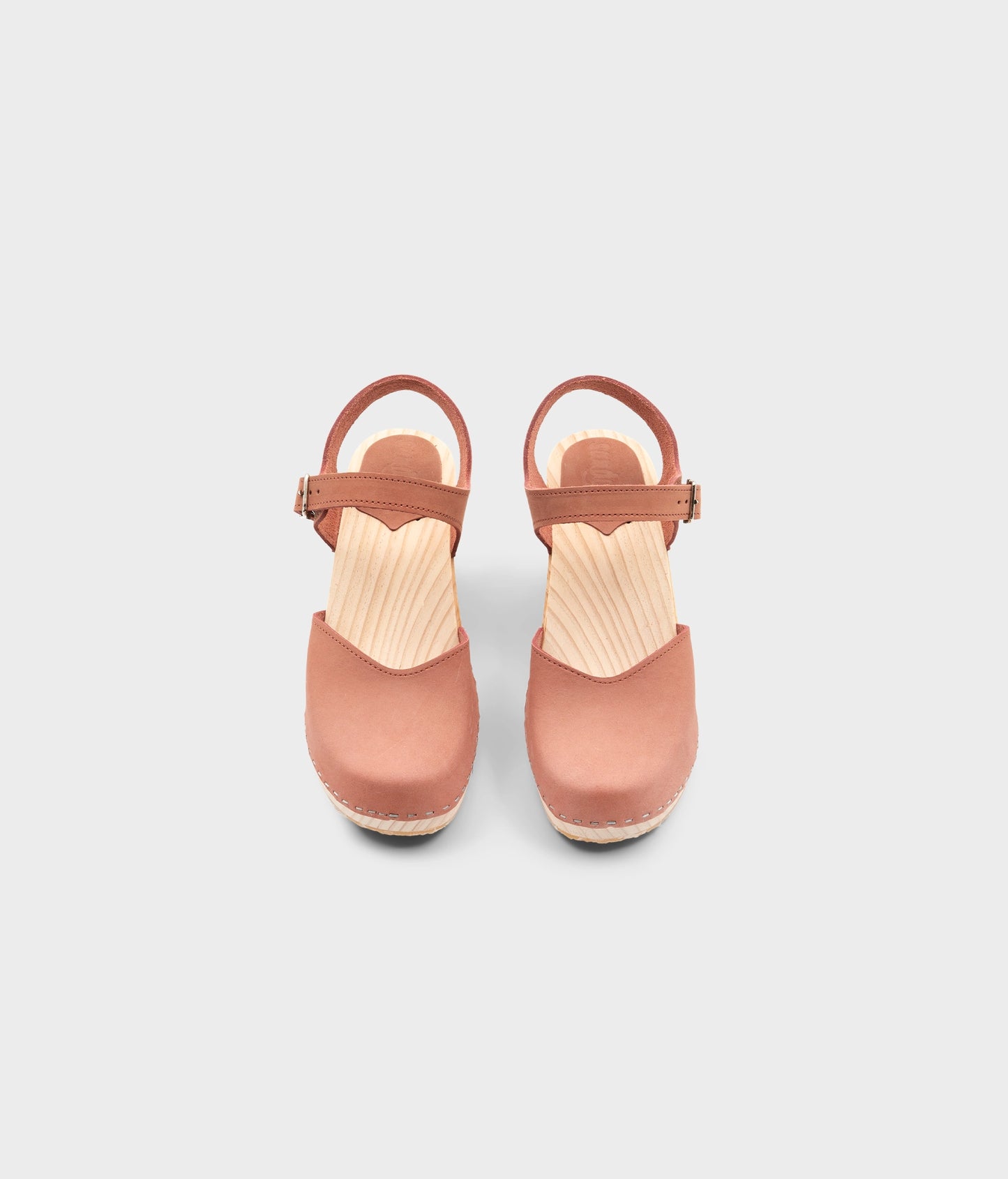 High rise heel classic clog sandals in blush pink nubuck leather stapled on a light wooden base