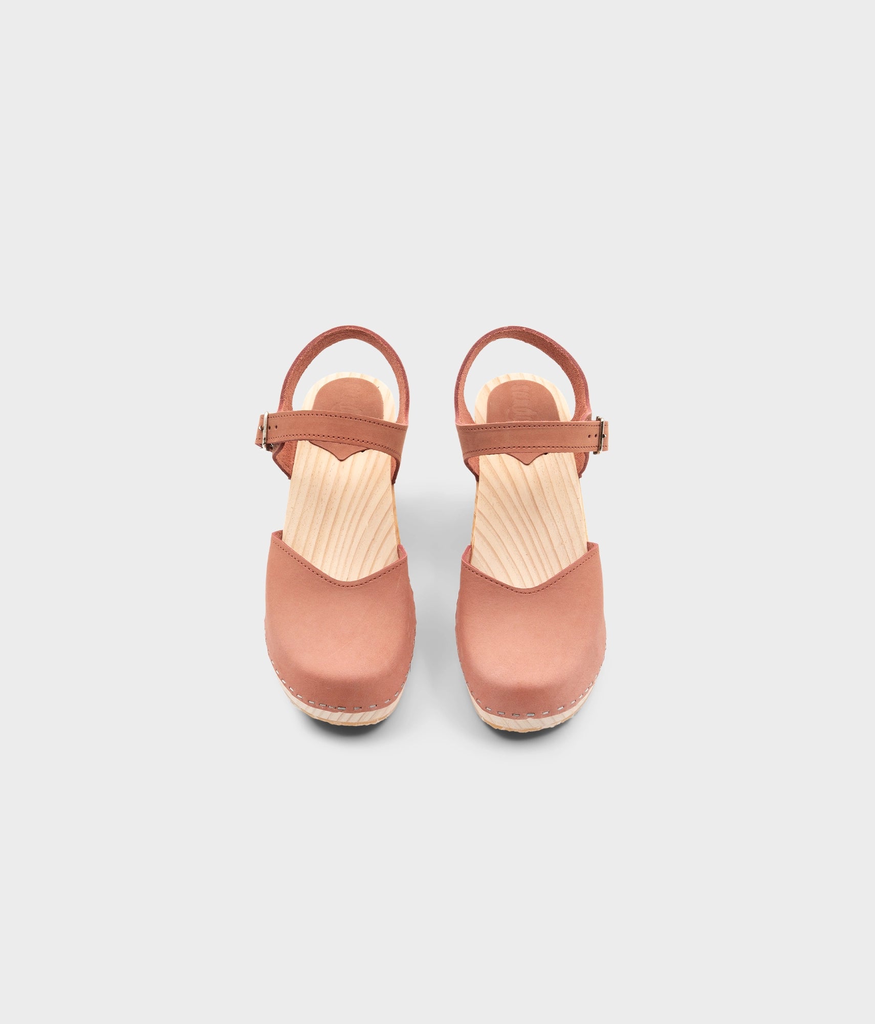 High rise heel classic clog sandals in blush pink nubuck leather stapled on a light wooden base