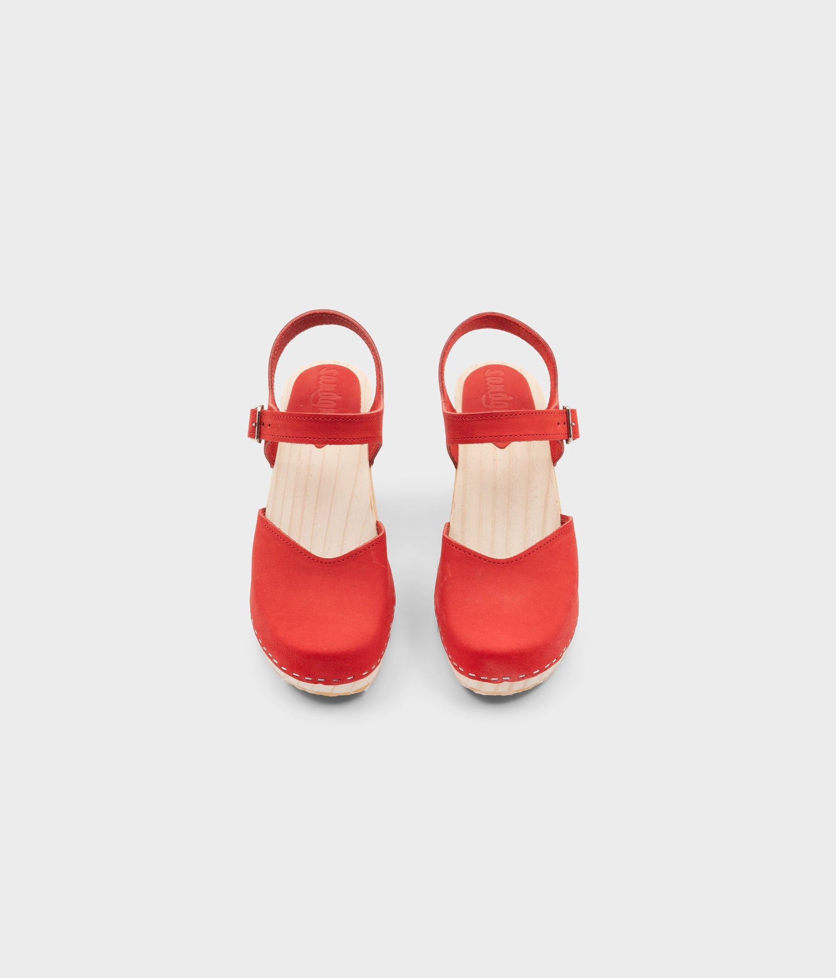 High rise heel classic clog sandals in red nubuck leather stapled on a light wooden base