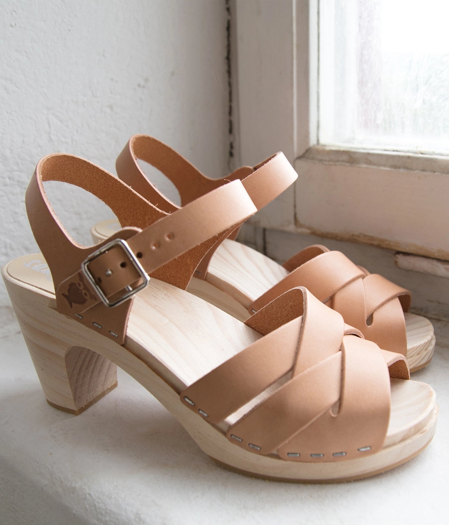 high-rise clog sandals in ecru beige vegetable tanned leather with an open-toe stapled on a light wooden base
