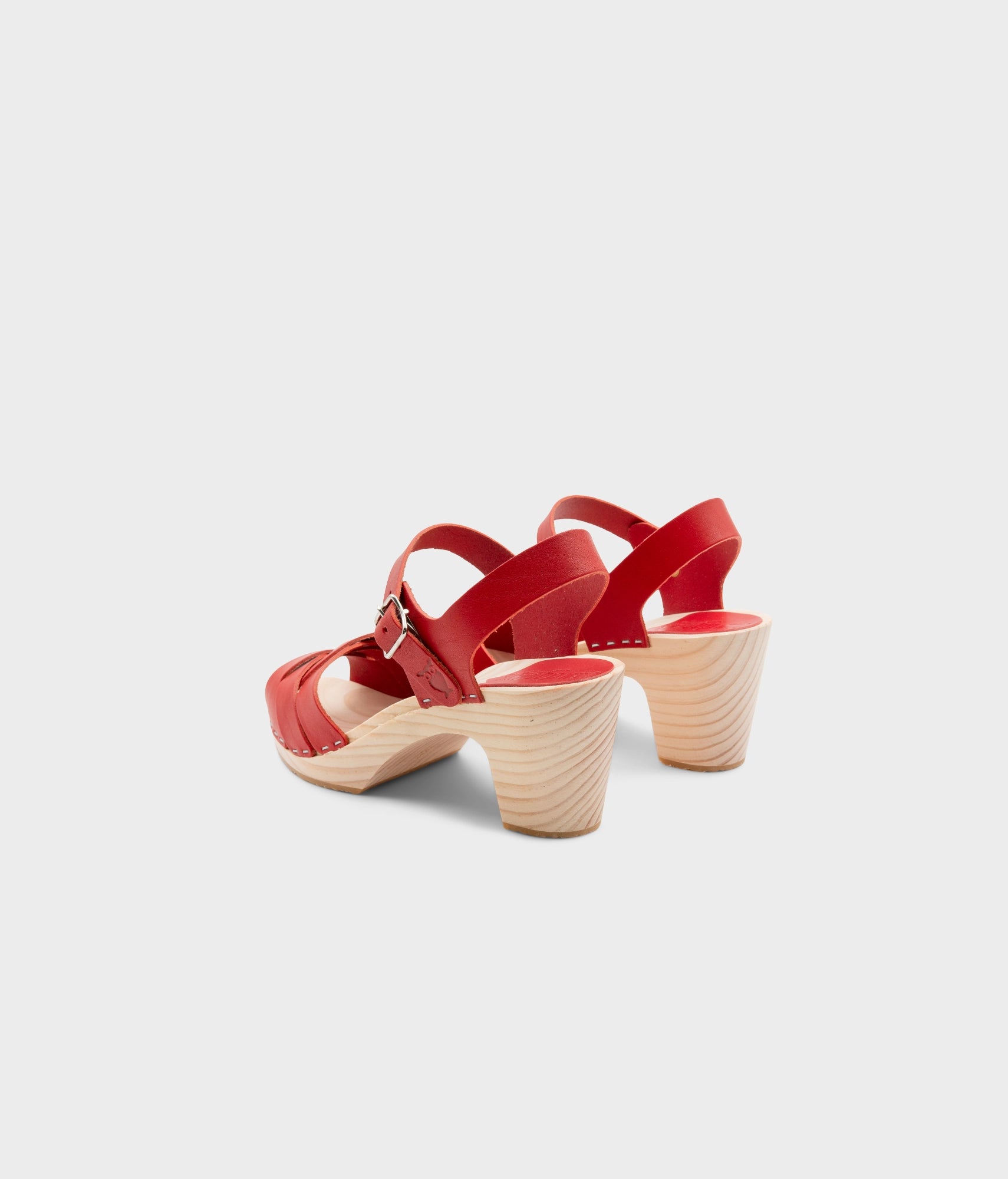 High rise heel clog sandals in red vegetable tanned leather stapled on a light wooden base with an open toe