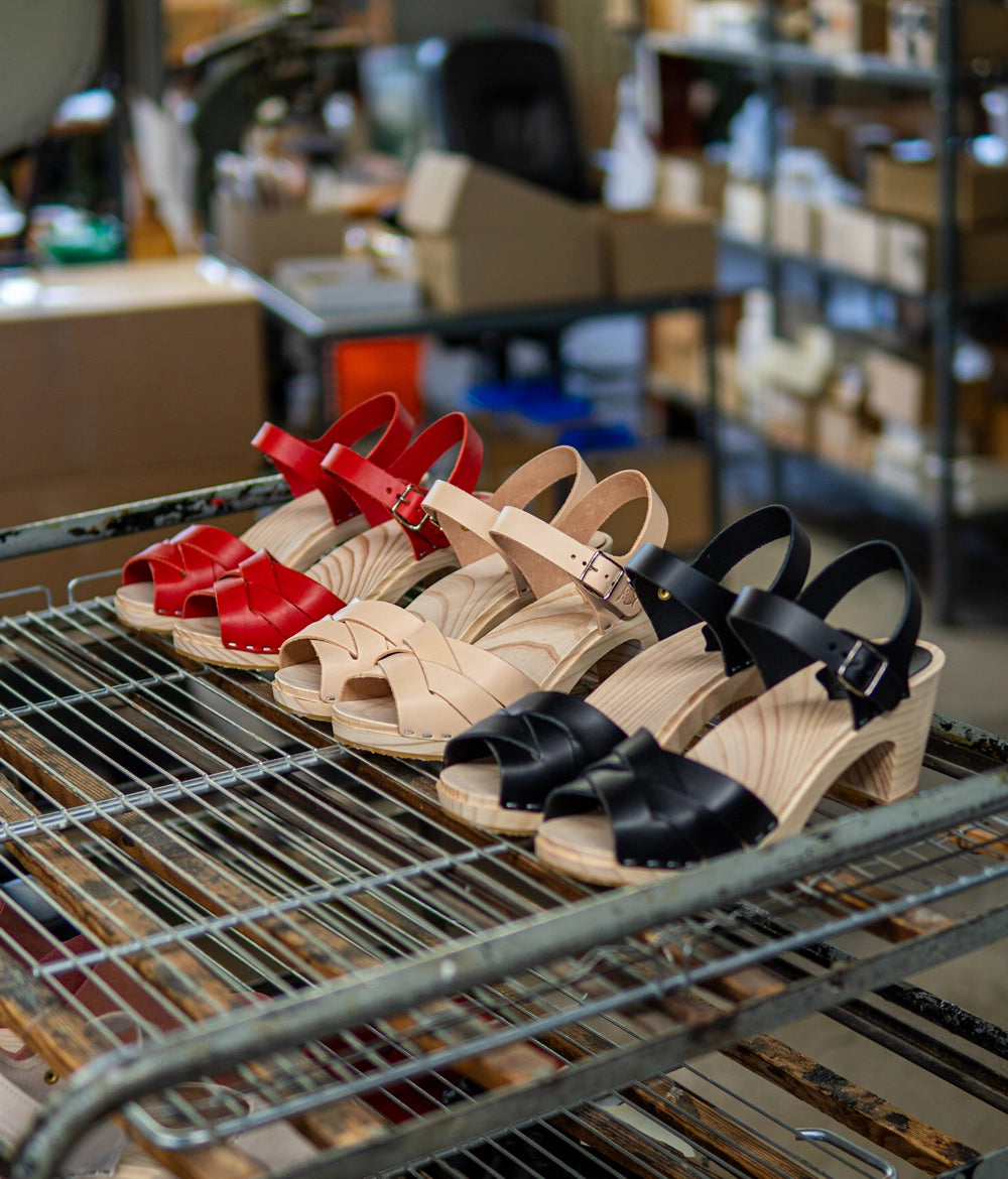High rise heel clog sandals in red vegetable tanned leather stapled on a light wooden base with an open toe
