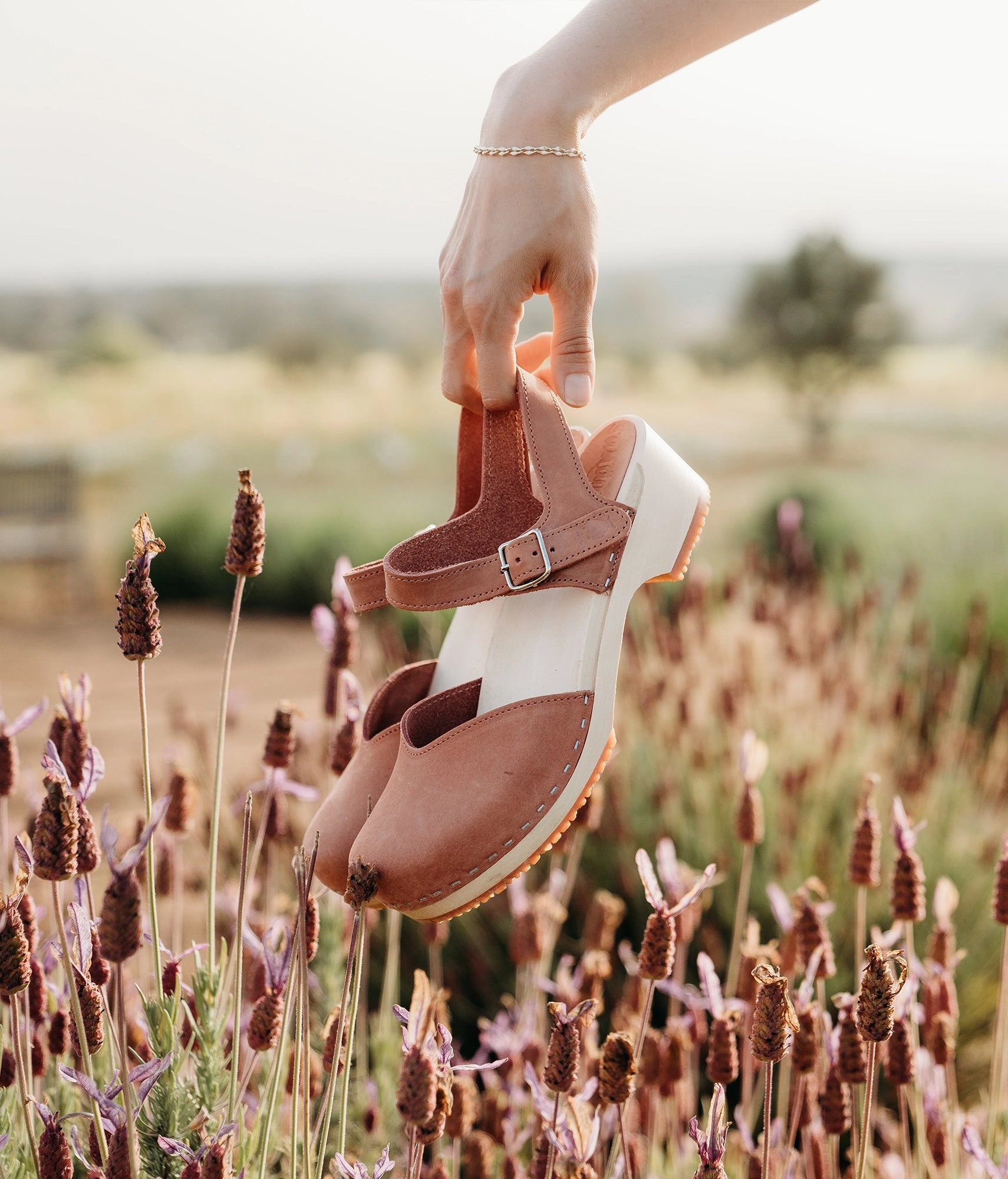 classic low heeled closed-toe sandal in blush pink nubuck leather stapled on a light wooden base