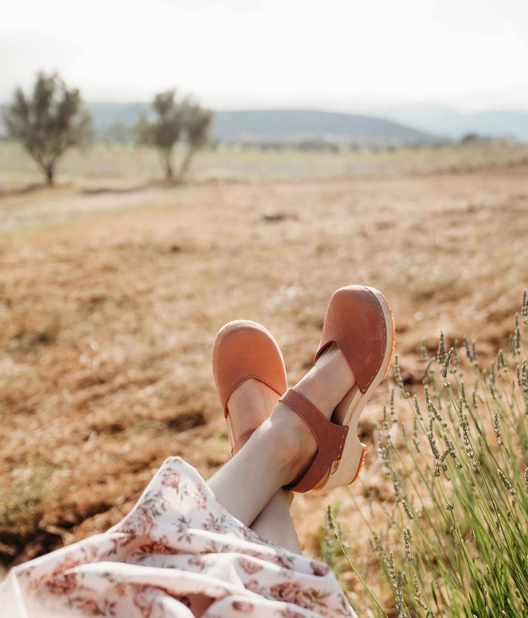 classic low heeled closed-toe sandal in blush pink nubuck leather stapled on a light wooden base