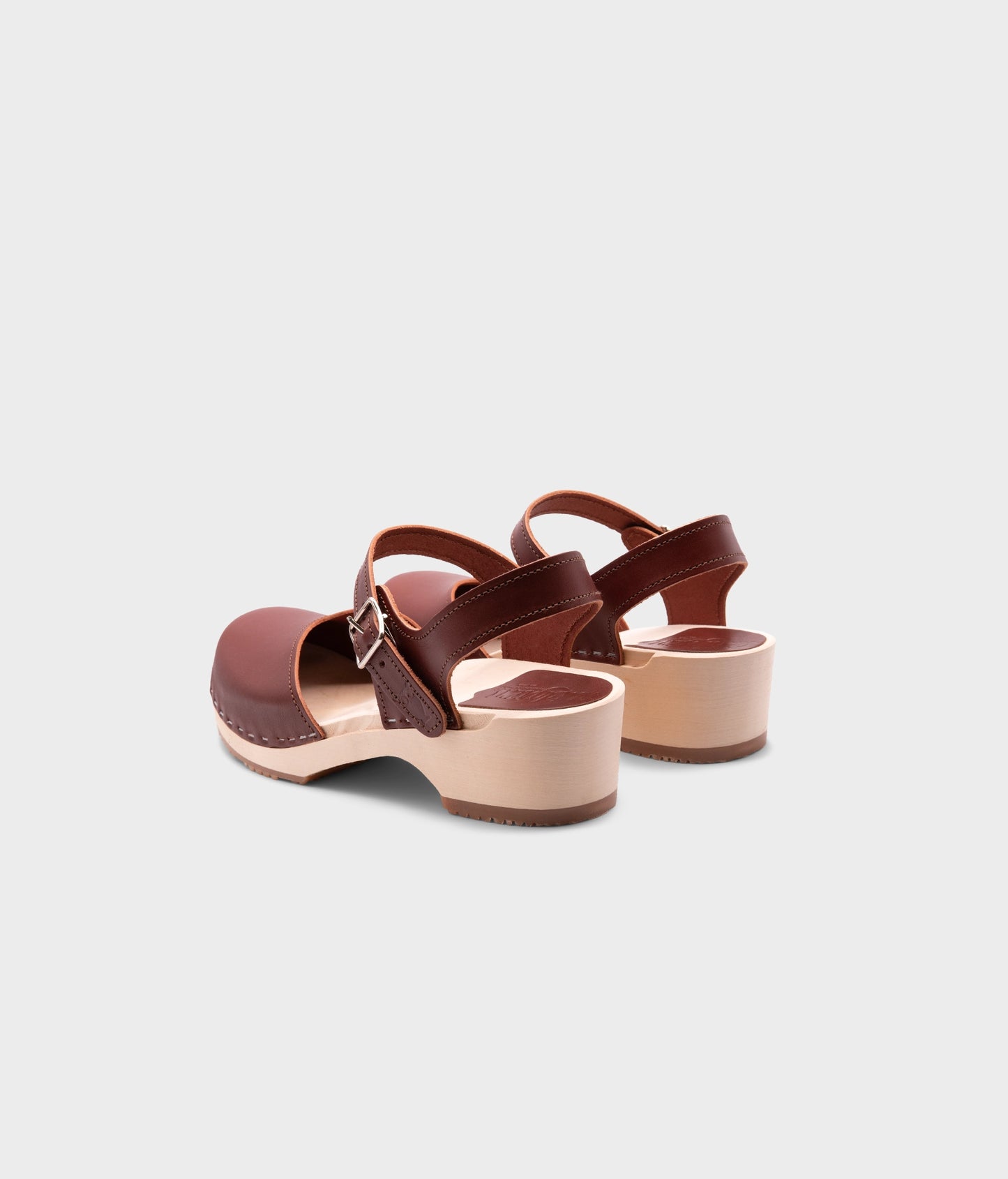 classic low heeled closed-toe sandal in cognac red vegetable tanned leather stapled on a light wooden base